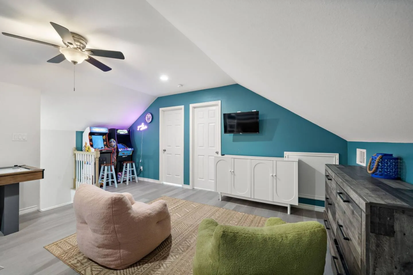 Additional view of the game loft with arcade games and TV.