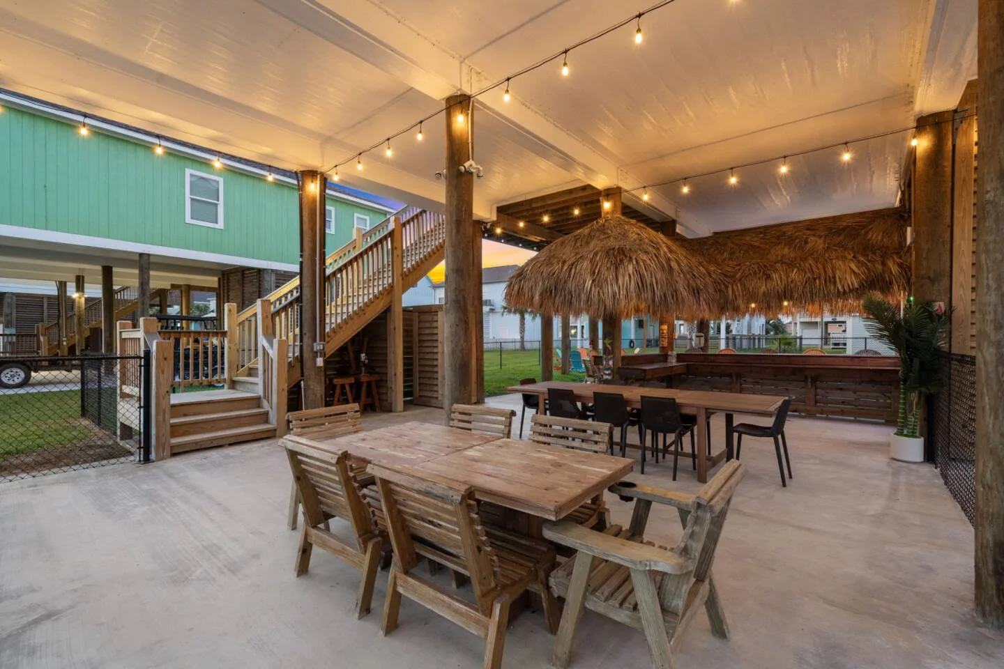 Covered outdoor dining and tiki-bar hangout beneath the house.